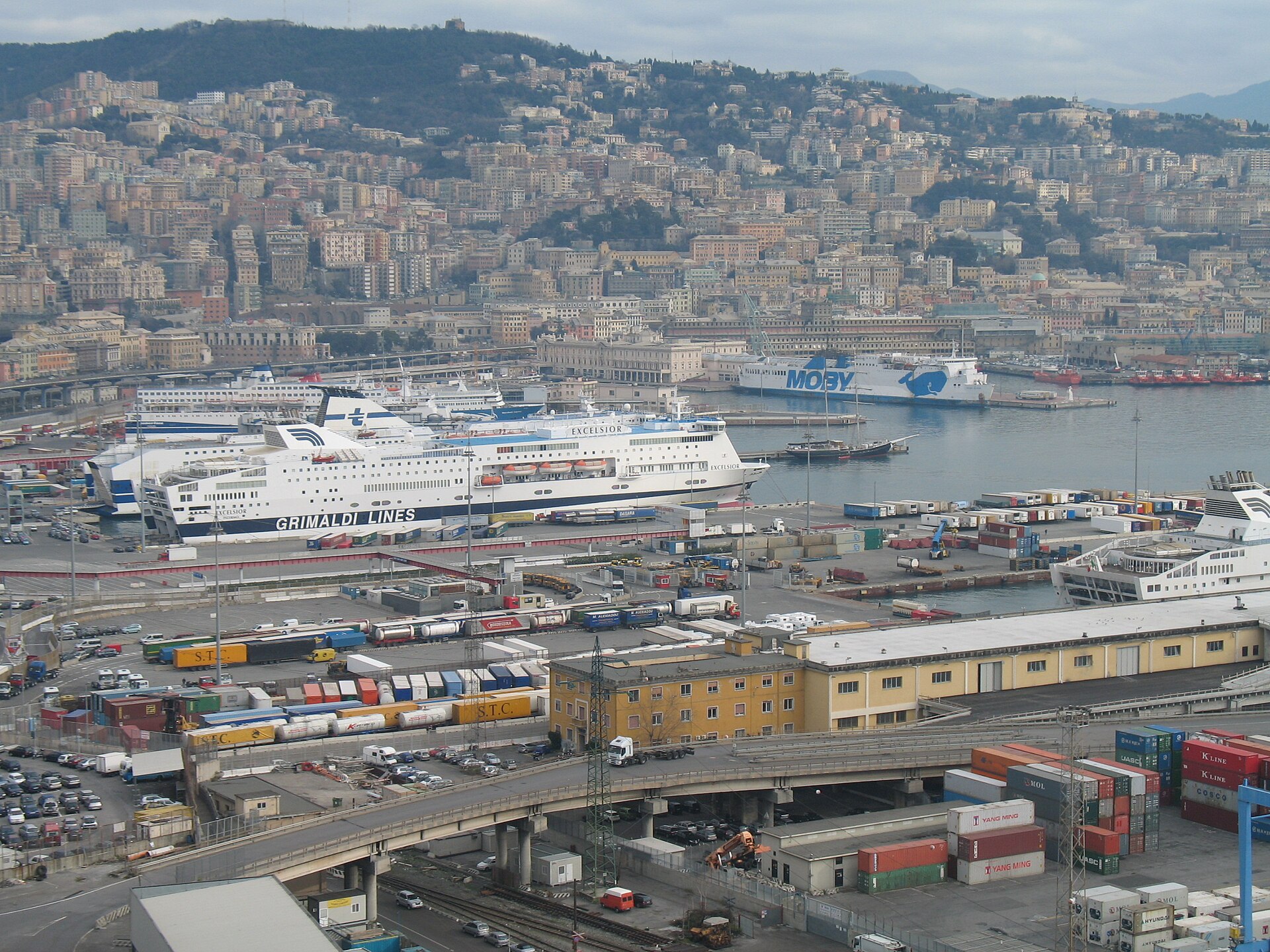 Ferries berthed below the hillside city of Genoa, with the historic maritime station building on the waterfront