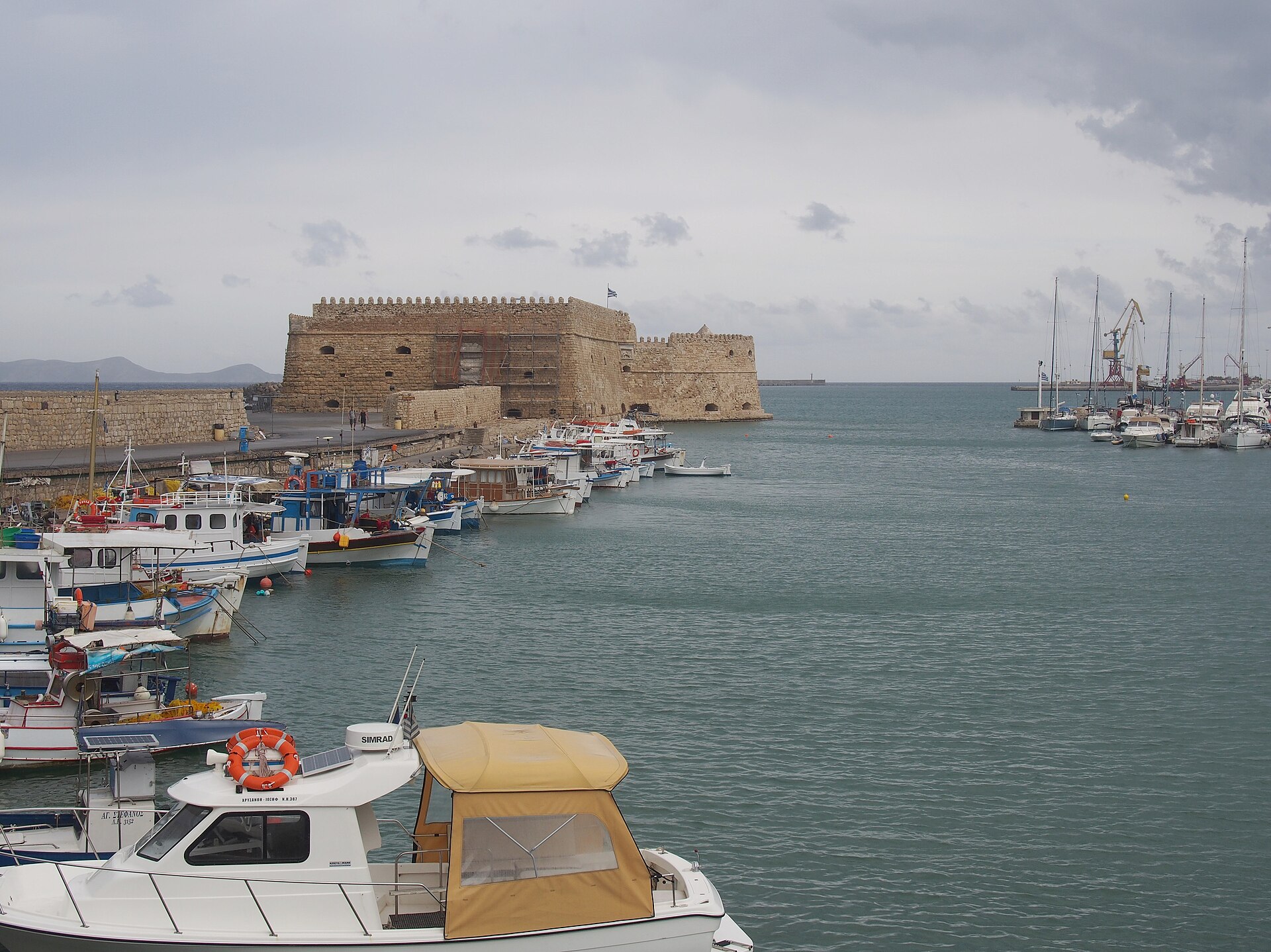 The Venetian Koules fortress at the entrance to Heraklion's old harbour with fishing boats moored along the quay