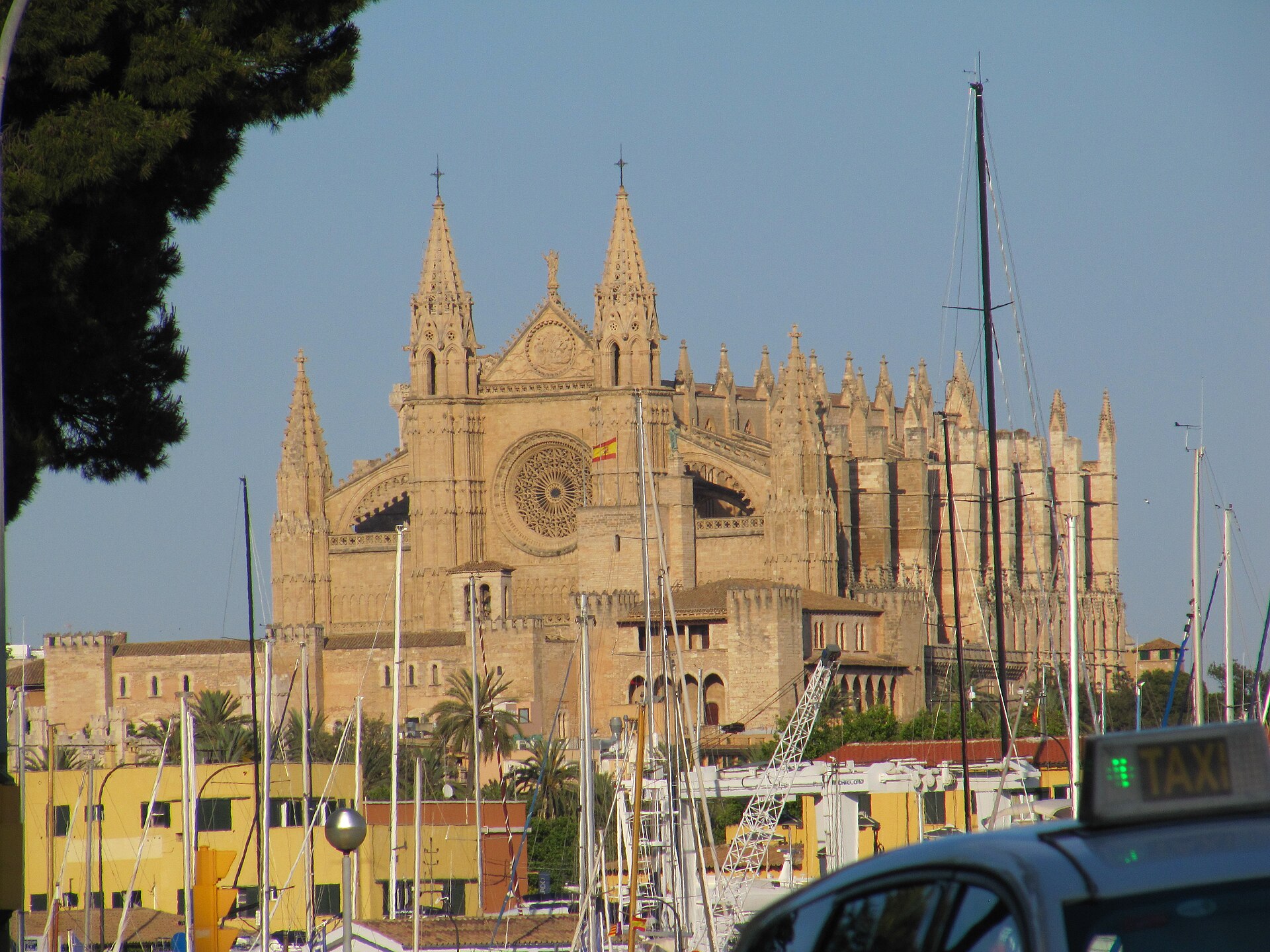 Palma Cathedral seen across the marina in Mallorca, with a taxi in the foreground