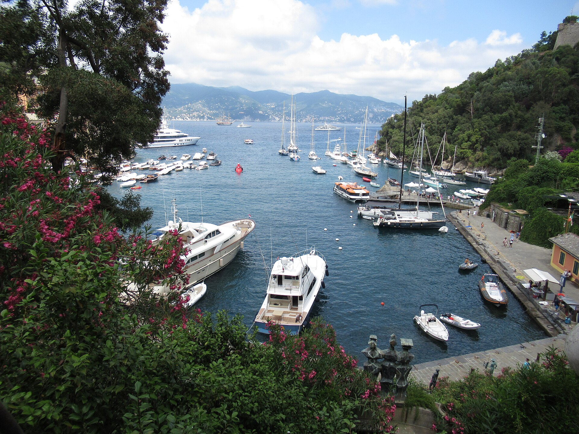 Yachts and small boats moored in the harbour at Portofino with the Ligurian coast beyond