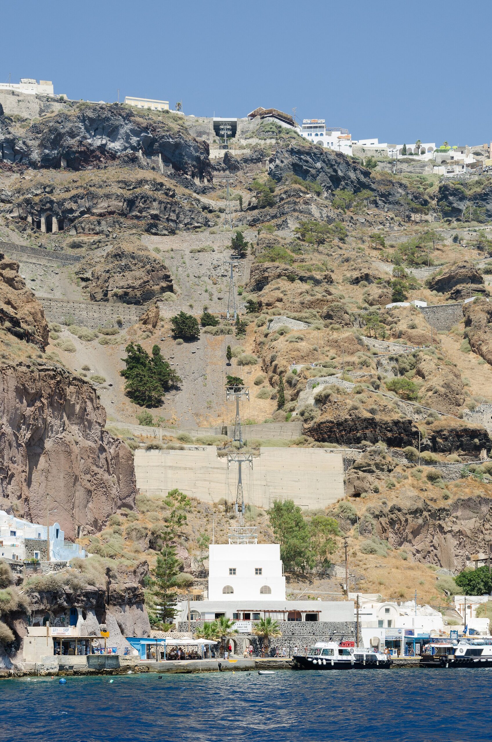 The Old Port of Santorini at the foot of the caldera cliff, with the cable car line running up to Fira