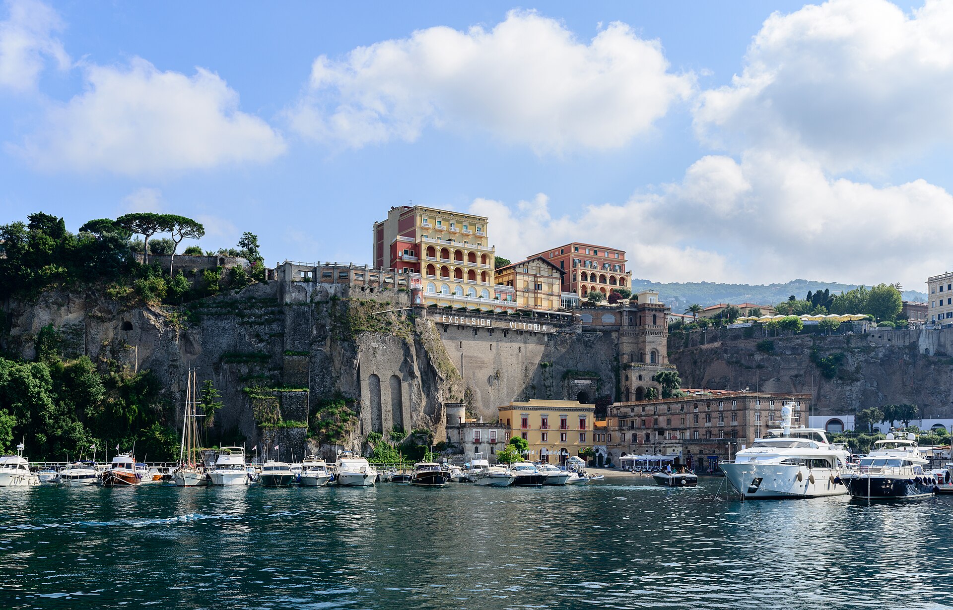 Sorrento's small harbour below the cliff, with grand hotels built along the clifftop above the boats